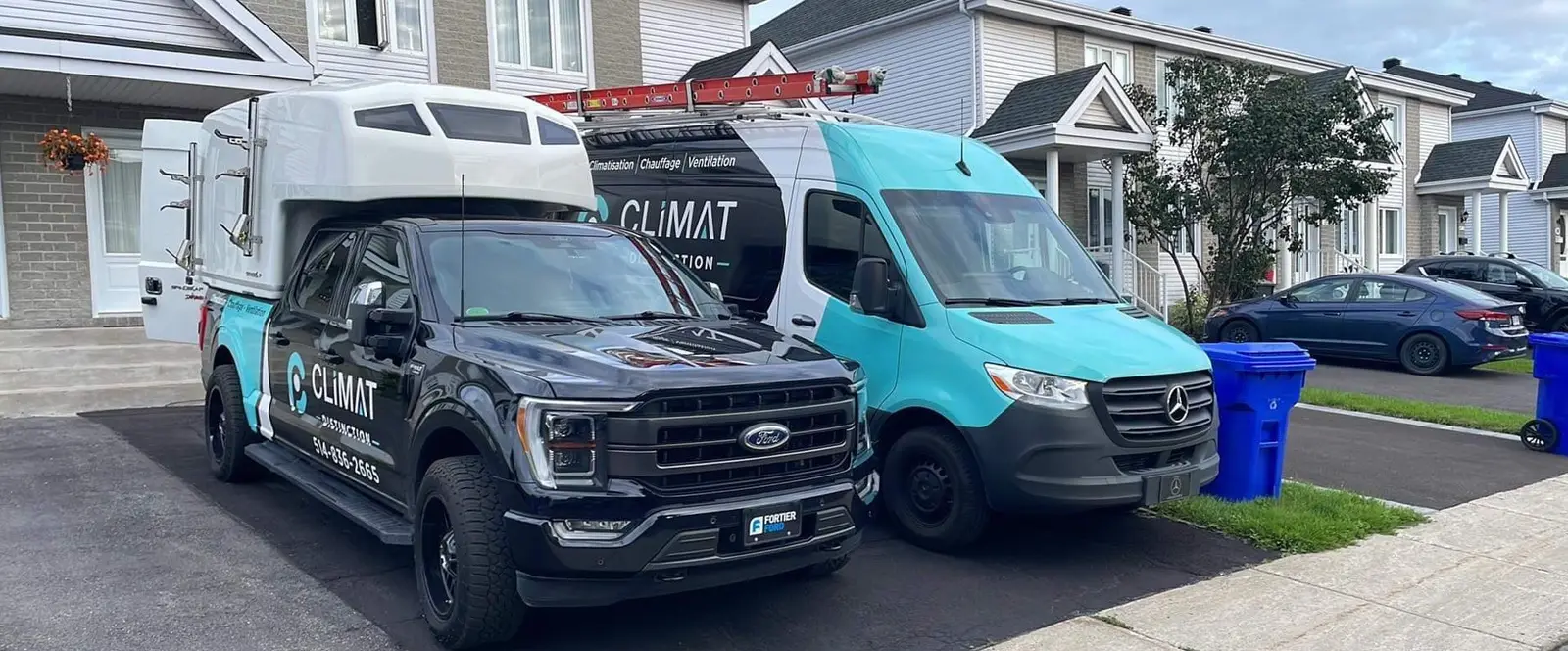 Camionnette et camion de service Climat Distinction stationnés devant une maison